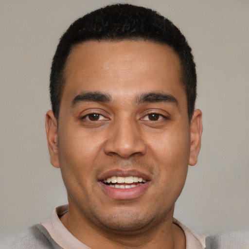 Joyful latino young-adult male with short  black hair and brown eyes