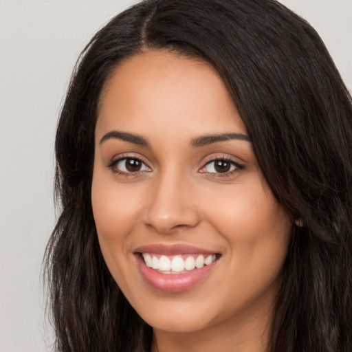 Joyful latino young-adult female with long  black hair and brown eyes