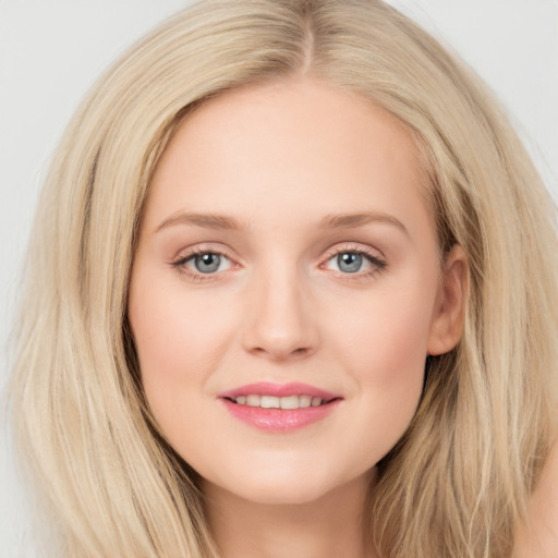 Joyful white young-adult female with long  brown hair and blue eyes