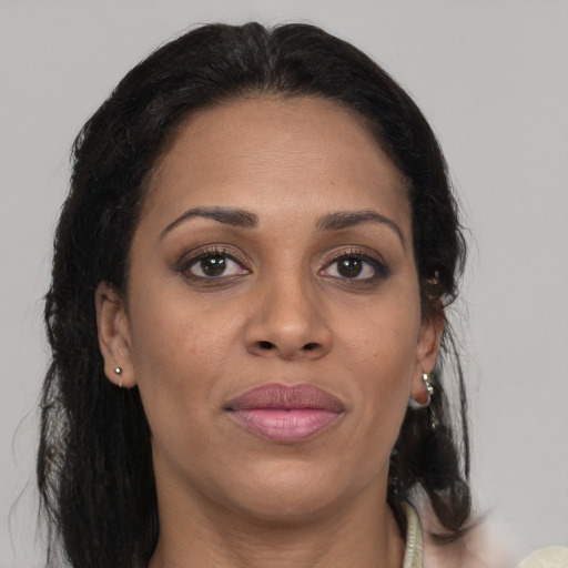 Joyful black young-adult female with long  brown hair and brown eyes