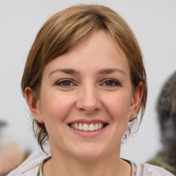 Joyful white young-adult female with medium  brown hair and grey eyes