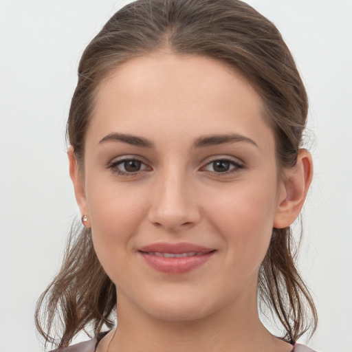 Joyful white young-adult female with medium  brown hair and grey eyes