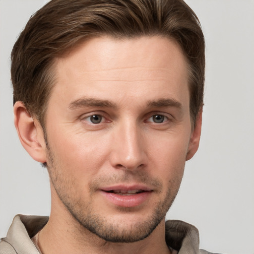 Joyful white young-adult male with short  brown hair and grey eyes