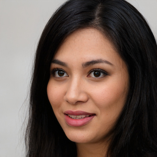 Joyful latino young-adult female with long  black hair and brown eyes