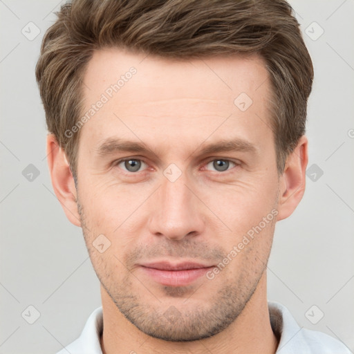 Joyful white young-adult male with short  brown hair and grey eyes