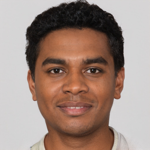 Joyful black young-adult male with short  black hair and brown eyes
