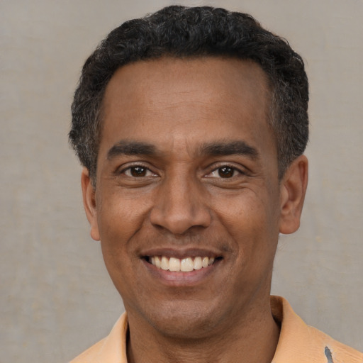 Joyful latino adult male with short  black hair and brown eyes