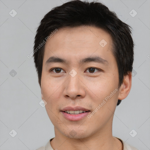 Joyful asian young-adult male with short  brown hair and brown eyes