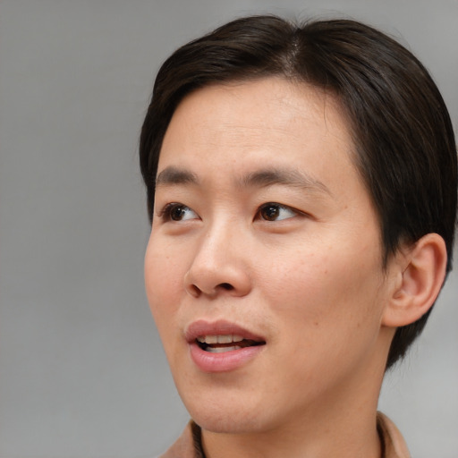 Joyful asian young-adult male with short  brown hair and brown eyes