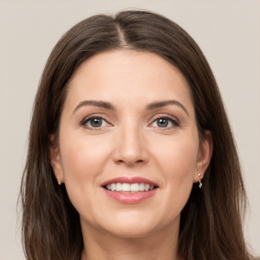 Joyful white young-adult female with long  brown hair and grey eyes