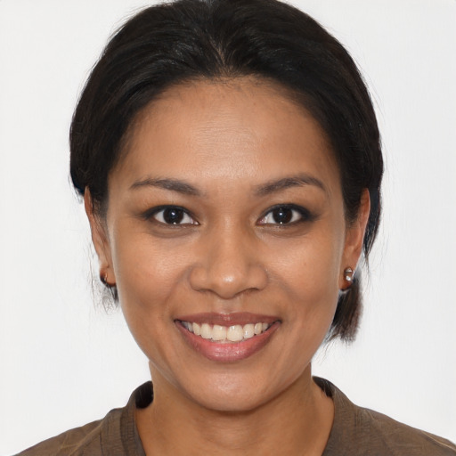 Joyful latino young-adult female with medium  brown hair and brown eyes