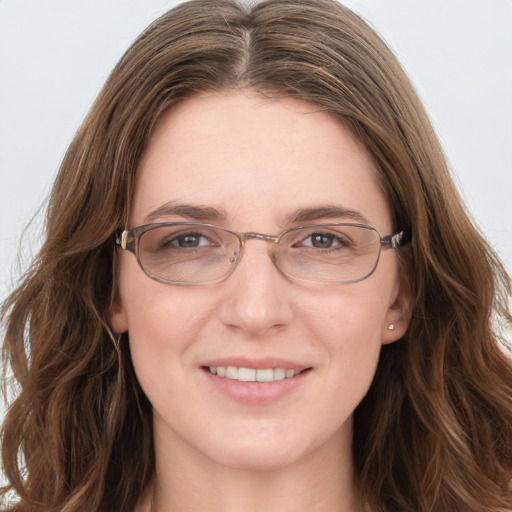 Joyful white young-adult female with long  brown hair and blue eyes