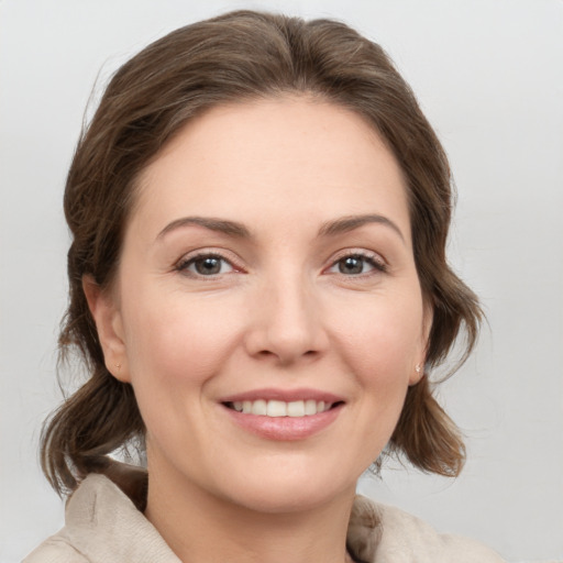 Joyful white young-adult female with medium  brown hair and grey eyes