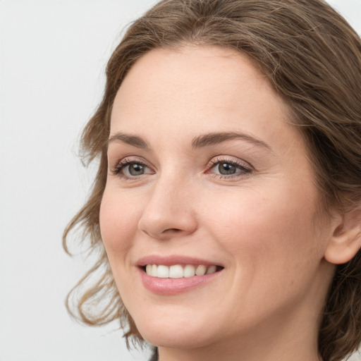 Joyful white young-adult female with medium  brown hair and grey eyes