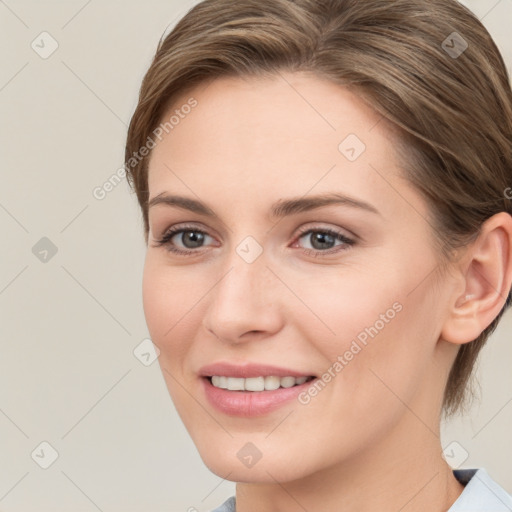 Joyful white young-adult female with medium  brown hair and grey eyes