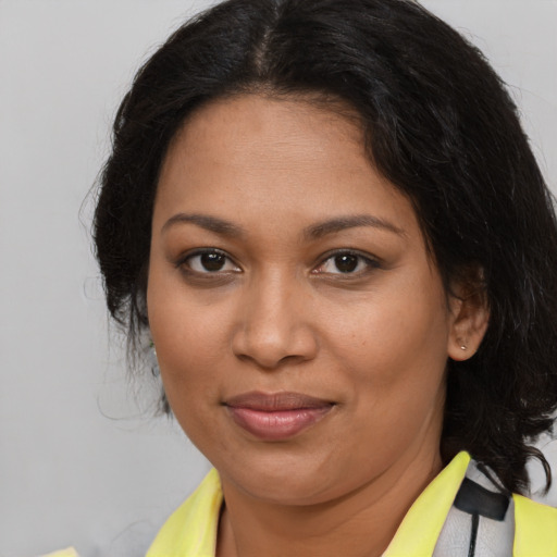 Joyful black adult female with medium  brown hair and brown eyes