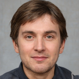 Joyful white young-adult male with short  brown hair and grey eyes