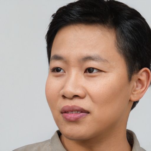 Joyful asian adult male with short  black hair and brown eyes