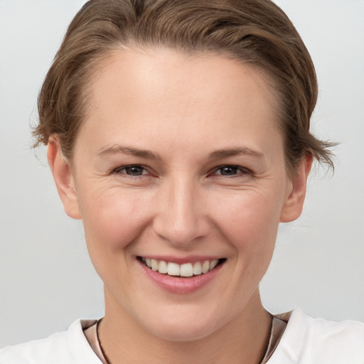 Joyful white young-adult female with short  brown hair and grey eyes