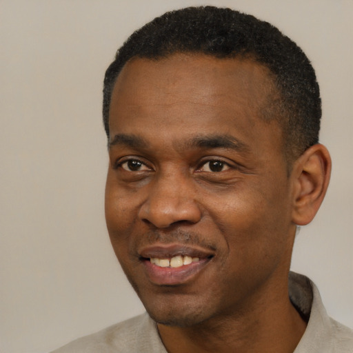 Joyful black young-adult male with short  black hair and brown eyes