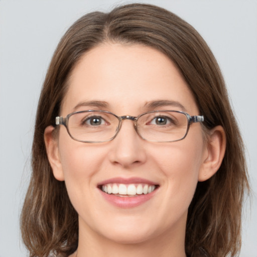 Joyful white adult female with medium  brown hair and green eyes