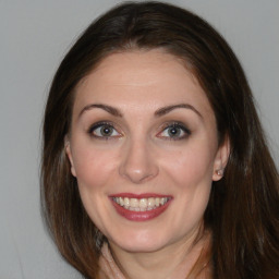 Joyful white adult female with long  brown hair and brown eyes