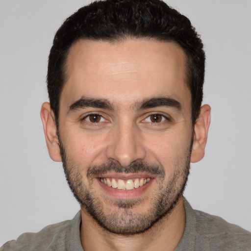 Joyful white young-adult male with short  black hair and brown eyes