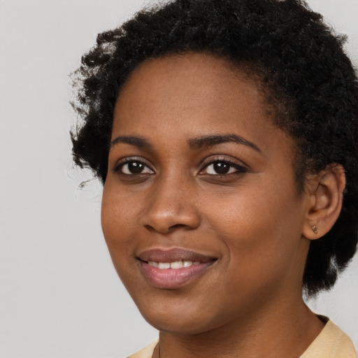 Joyful black young-adult female with short  brown hair and brown eyes