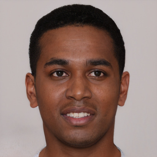Joyful black young-adult male with short  brown hair and brown eyes