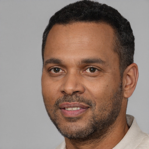 Joyful black young-adult male with short  black hair and brown eyes