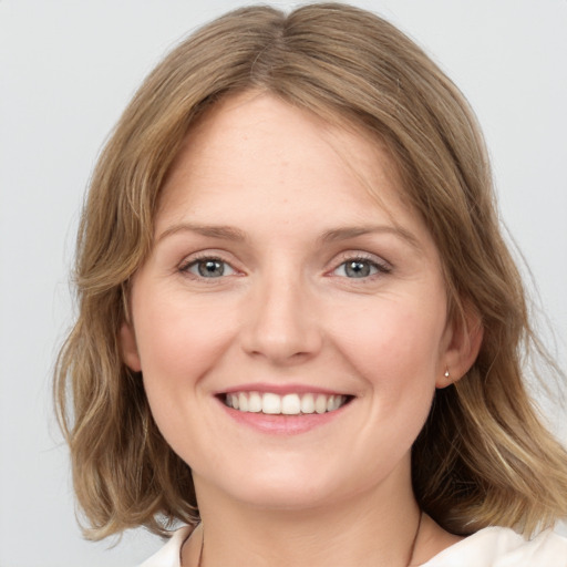 Joyful white young-adult female with medium  brown hair and blue eyes