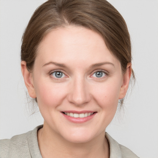 Joyful white young-adult female with medium  brown hair and blue eyes