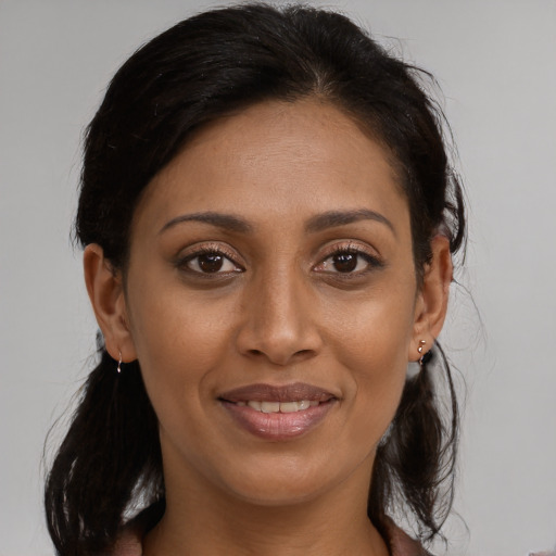 Joyful black young-adult female with medium  brown hair and brown eyes