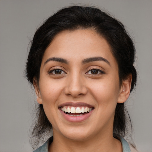 Joyful latino young-adult female with medium  brown hair and brown eyes