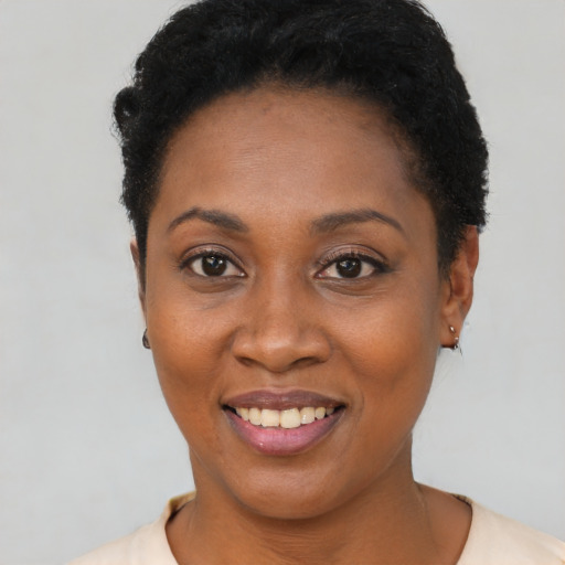Joyful black young-adult female with short  black hair and brown eyes