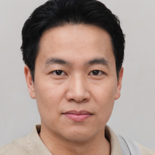 Joyful asian adult male with short  black hair and brown eyes