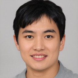 Joyful asian young-adult male with short  black hair and brown eyes