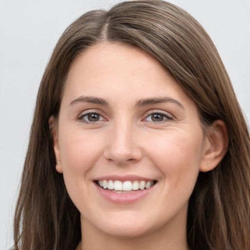 Joyful white young-adult female with long  brown hair and grey eyes