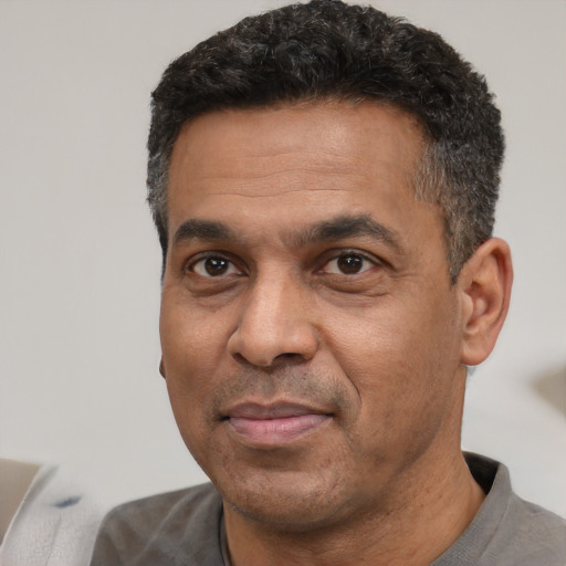 Joyful latino adult male with short  black hair and brown eyes