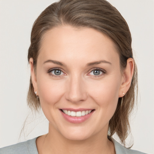 Joyful white young-adult female with medium  brown hair and grey eyes