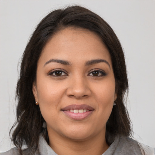 Joyful latino young-adult female with medium  brown hair and brown eyes