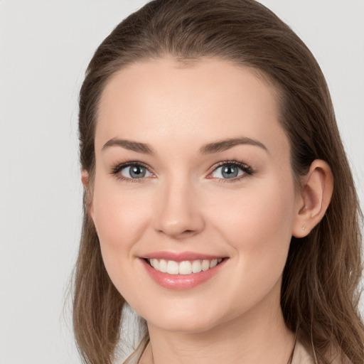 Joyful white young-adult female with long  brown hair and grey eyes