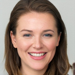 Joyful white young-adult female with long  brown hair and grey eyes