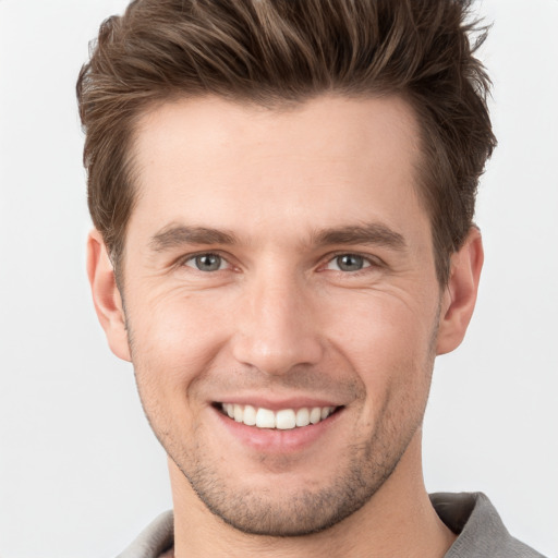 Joyful white young-adult male with short  brown hair and grey eyes