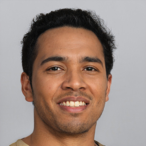 Joyful latino young-adult male with short  black hair and brown eyes