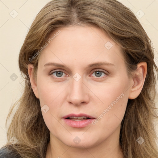 Joyful white young-adult female with long  brown hair and blue eyes