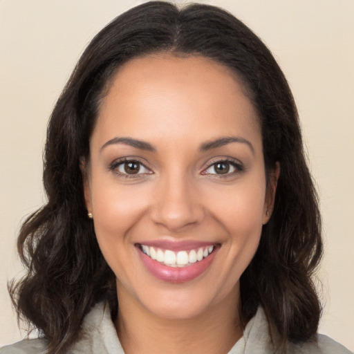 Joyful latino young-adult female with long  brown hair and brown eyes