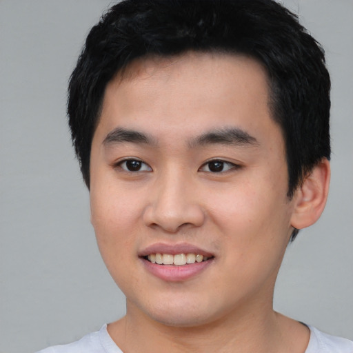 Joyful asian young-adult male with short  black hair and brown eyes