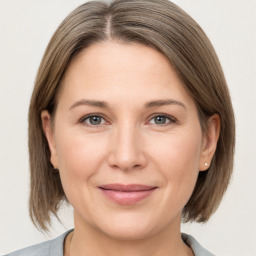 Joyful white adult female with medium  brown hair and grey eyes