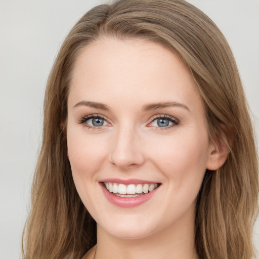 Joyful white young-adult female with long  brown hair and blue eyes